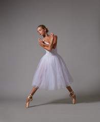Ballerina dancing in white dress. Color photo.