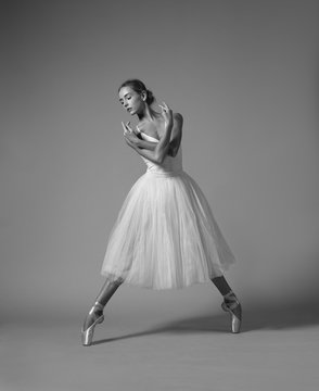 Ballerina dancing in white dress. Black and white photo.