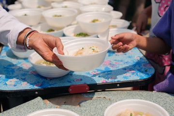 Hand begging for food from the rich's share : The beggar is waiting for food from charity aid : the concept of begging and hunger : Hunger problems of the poor have been donated food to reduce hunger