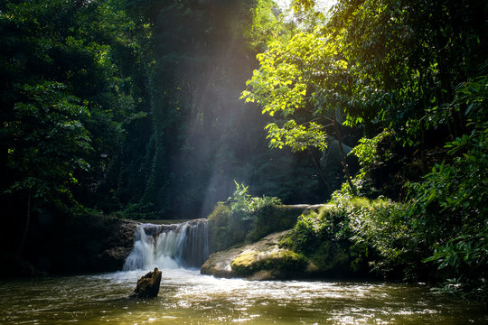 Mini waterfall and sunset sunny beams, travel destinations background, Forest viwe river Kroeng Krawia Waterfall, Kanchanaburi, Thailand