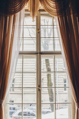 wooden window with vintage curtains and square molding on a sunny day. beige satin curtains. interior. background for collage