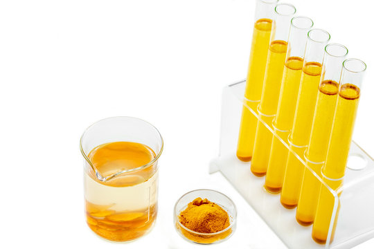 Healthcare Resaerch on Curcuma. test tube with mater and curcuma with turmeric powder and turmeric root on White background