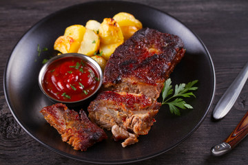 Roasted pork spare ribs with potatoes. Grilled meat. horizontal