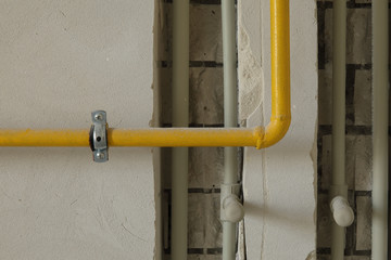 Yellow gas pipe on residential house wall.