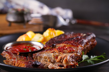 Roasted pork spare ribs with potatoes. Grilled meat. horizontal
