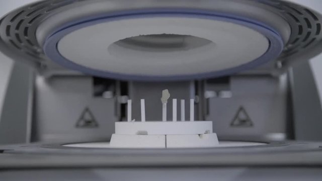 Artificial teeth in extremely high temperature oven in dental clinic. Dental technician bakes ceramic teeth in special furnace machine. Teeth reconstruction process in dental laboratory by technician