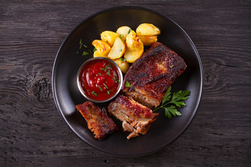 Roasted pork spare ribs with potatoes. Grilled meat. overhead, horizontal