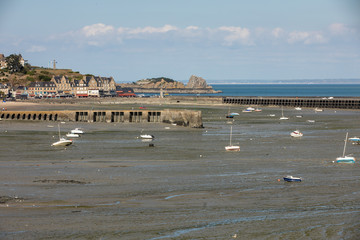 Boats on dry land at the beach at low tide in Cancale famous oysters production town, Brittany, France,