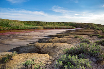 View of small red water river full of iron in beautiful steppe