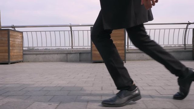 Closeup shoot of young african american businessman performing a moonwalk on the street in the urban city