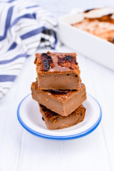 Chocolate cake with salt and caramel cookies on a white background. Traditional American dessert cut into portions. Free space for text. Copy space.