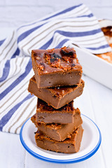 Chocolate cake with salt and caramel cookies on a white background. Traditional American dessert cut into portions. Free space for text. Copy space.