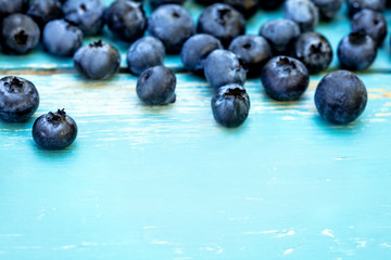Viele Blaubeeren, frische Beeren auf blauem Holz mit Textfreiraum