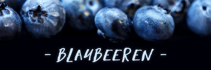 Kulturheidelbeeren auf Untergrund schwarz mit Wort Blaubeeren