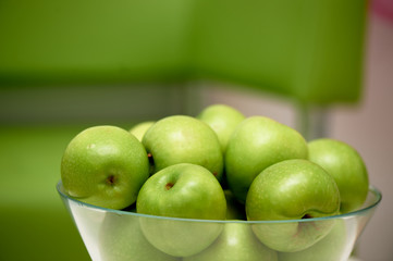 Glass vase with green apples. Fresh juicy fruits, vegetarian food.