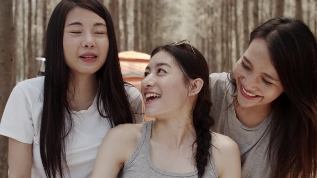 Teenager female using smartphone vlog video and live in social media, Group  of young Asian friends camping in forest. Adventure activity and travel on holidays vacation in summer. Slow motion shot.