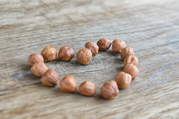 brown heart of hazelnuts on a wooden oak board
