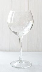Empty wine glass on a light background. Glass container