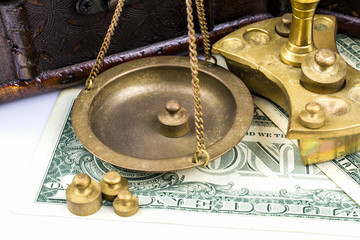 Naklejka premium Scales of bronze, weights, bills for one dollar close-up.