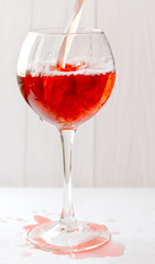 A glass of red wine, bottling, movement. Selective focus.