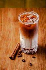 Iced coffee with ice. Frappe, frappuccino with cream and cinnamon on a wooden table. copy space