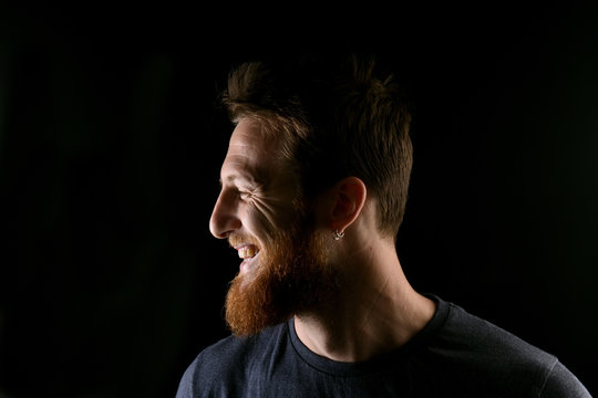 portrait of profile of a smiling man on black background