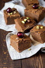 Pieces of Homemade Chocolate Brownies With Cherry and Nuts Lying on Linen Napkin Vertical