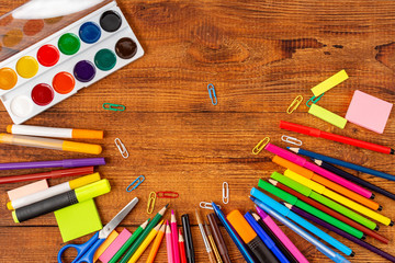 colorful pencils, markers and pens composition mock-up Back to school concept with stationery office supplies on a brown wooden background with copy space top view