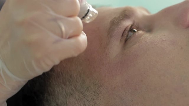 Close up view of hydrating facial procedure around the eyes area for males slow motion