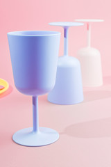 Bright colored plastic picnic utensils. Pink, yellow, blue colors in the bowl. Photo in hard light. Copy space