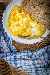 Scrambled eggs served with bread.