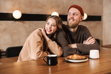Happy young loving couple in cafe drinking coffee have a breakfast.