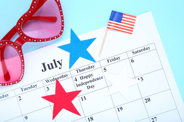 Text Happy Independence Day in calendar with american flag and sunglasses on blue background