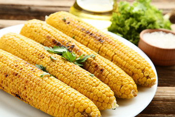 Grilled corn with green parsley on brown wooden table