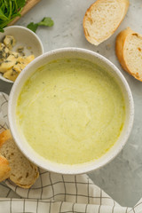 Broccoli cream soup in white bowl, top view