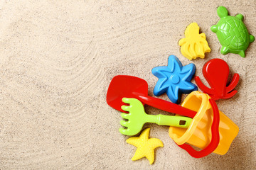 Colorful plastic toys on beach sand