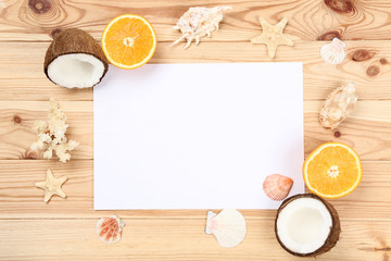 Blank sheet of paper with seashells and fruits on brown wooden table