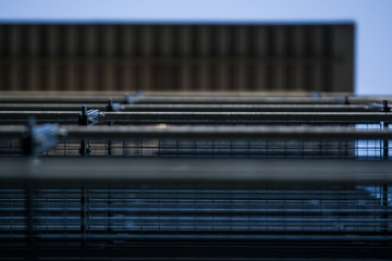 Background or texture in the blue sky of a crossbeam from building lattices. View of balconies from below. Cage, grid, wire.