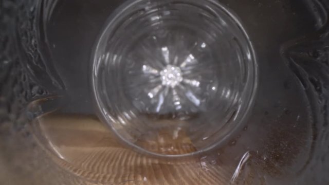 Inside the plastic bottle. Dolly macro shot of camera zooming in empty water bottle on wooden background