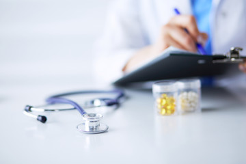 Stethoscope lying on glass desk with laptop computer at busy physician background. Medicine or pharmacy concept. Medical tools at doctor working table