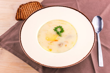 Cheese soup in a white plate with toasted bread