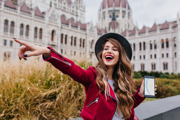 Glad european woman using gps during vacation in Europe. Outdoor photo of emotional young lady with...
