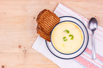 Cheese soup in a white plate with toasted bread