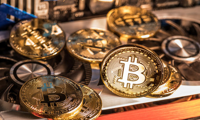 Shiny physical bitcoins and record-keeping equipment. Mining farm.