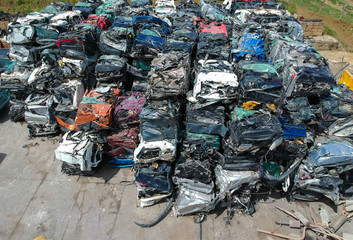 Cars in junkyard, pressed and packed for recycling.