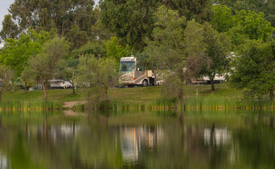 Obraz premium Rv Camping along the shore at Lake Camanche in the spring with reflection in water