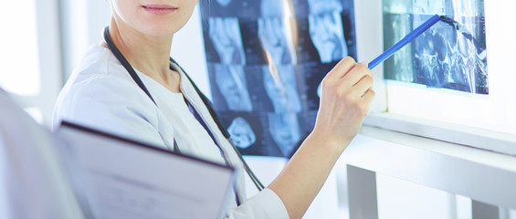 Two smiling doctors pointing at x-rays in a hospital consulting room