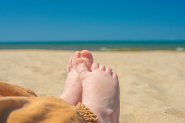 bare children's feet on the beach. close-up