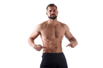 Fototapeta na wymiar Athlete with a strong torso shows fingers on the cubes on his stomach. Muscular man shows his abs, isolated on white background
