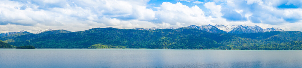 Panorama of Lake with mountains, cloudy sky in background